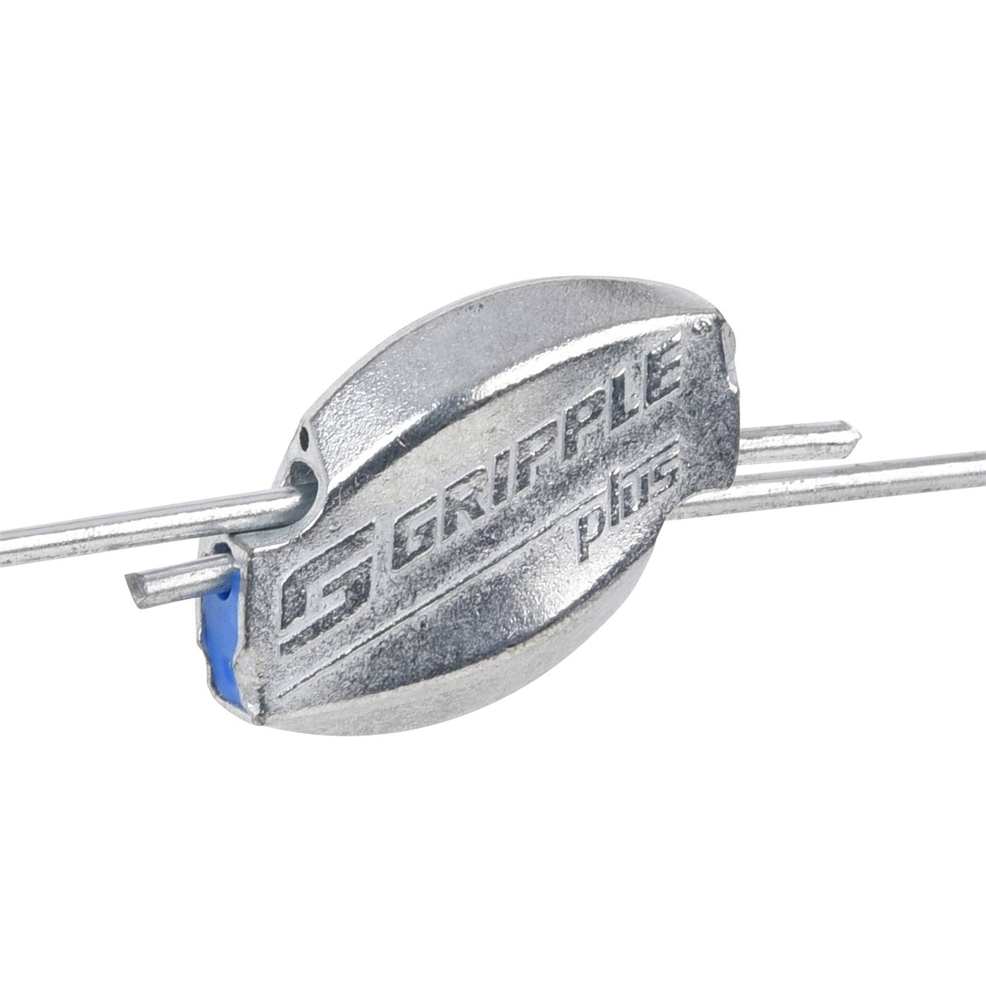 Une vue rapprochée d'un connecteur Gripple 5x "moyen" (Ø 2,0-3,25 mm) de Gripple pour sécuriser les fils de clôture métalliques en extérieur sur une pelouse.